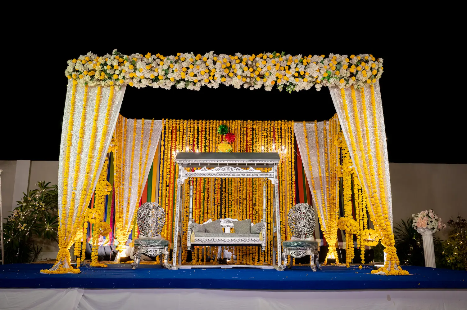 Mehndi event decor setup with colorful stage